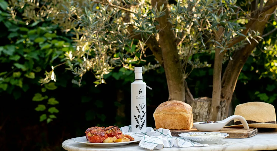 Pan rústico, aceite de oliva y tomate en una mesa mediterránea
